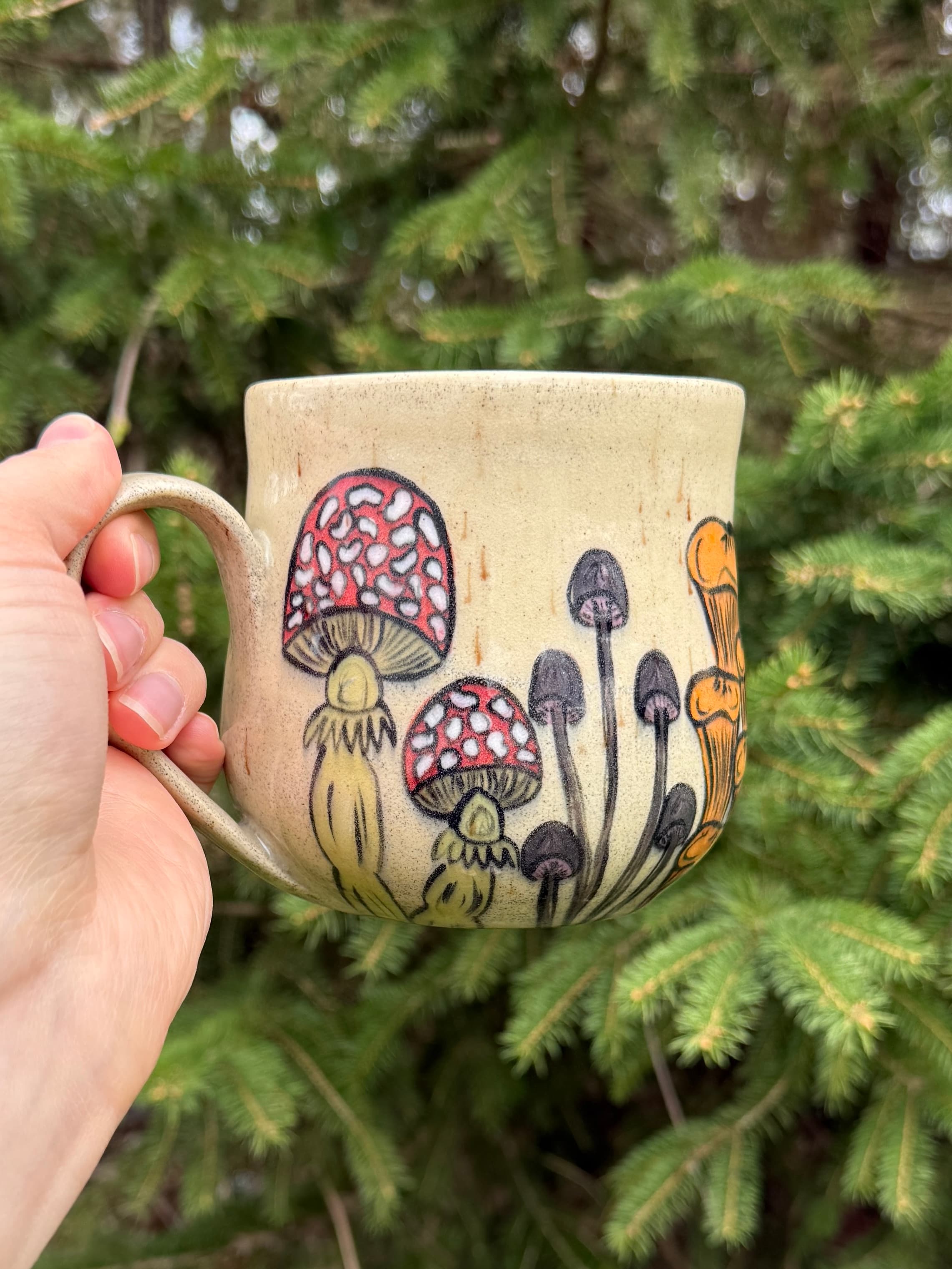Hand painted mushroom ceramic mug with whimsical toadstool design on cream stoneware